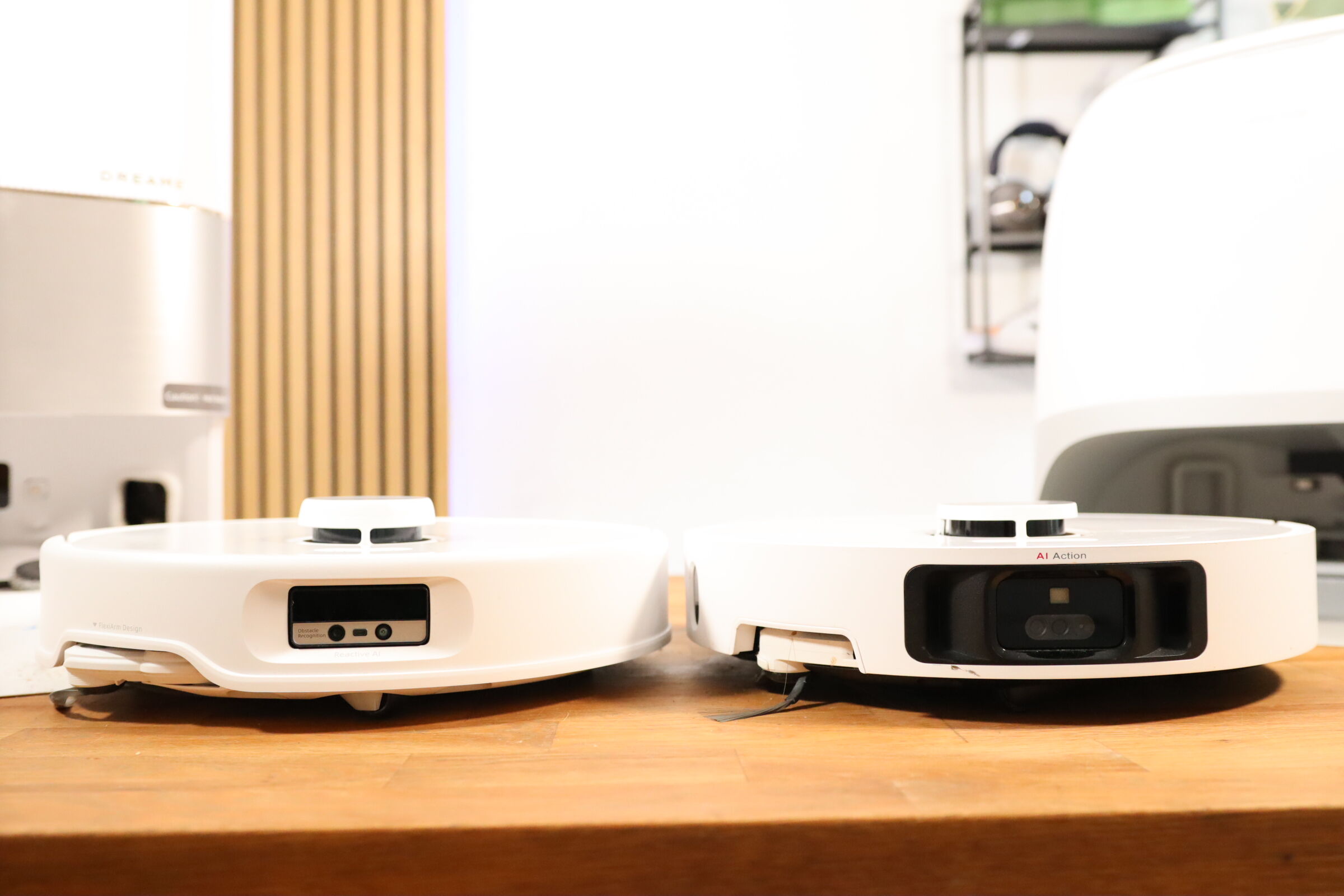 Роботы-пылесосы Roborock и Dreame стоят рядом друг с другом.